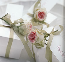 Az esküvő színvilágát az ajándékoknak is visszhangozniuk kell. A kulcsszínek itt a rózsaszín és a zöld, amelyeket viszontlátunk a csomagokat díszítő rózsákon és szalagokon.